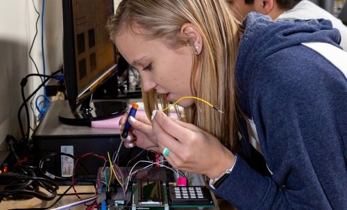 A student tinkers with a disassembled calculator