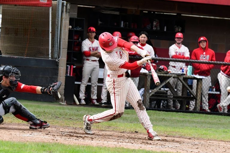 A Saints baseball player takes a swing during a game