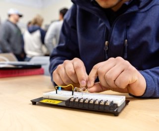 Photo of student conducting mechanical engineering in robotics
