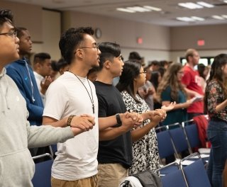 Students hold hands in rows