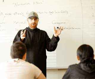 A monk teaches at the front of the class