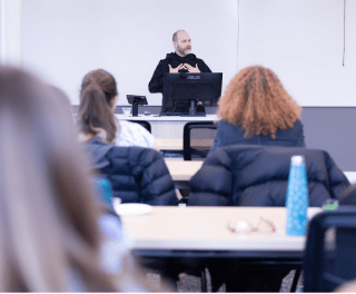 A monk teaches at the front of a class