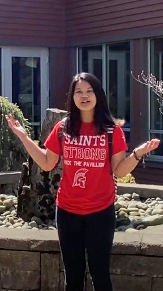 A student in a Saints shirt gestures while giving tour
