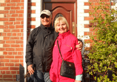 Tom and Pat Barte in front of a brick building