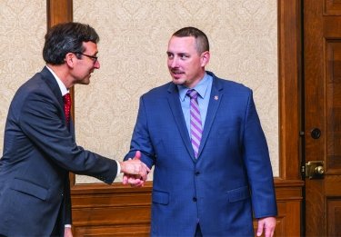 Joshua Penner shakes hands with an official
