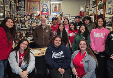 Students stand with Fr. Greg Boyle in his office at Homeboy Industries