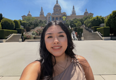 Student selfie in front of ornate building with grad staircase