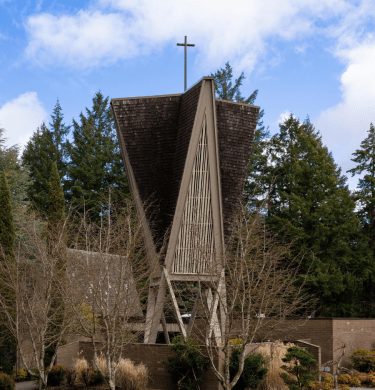 Building with cross at top under a partially cloudy sky