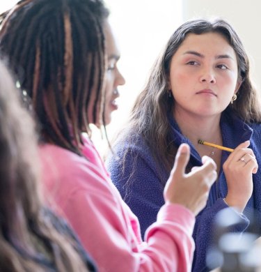 A student listens to another speak in class