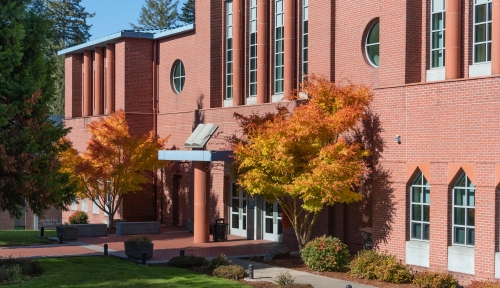 Facade of O'Grady Library with trees in autumn colors.