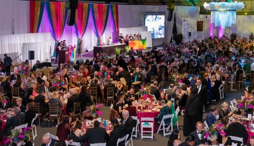 Crowds of attendees sit at round tables facing the stage, where Chef Anne Burrell does her cooking demonstration on a raised platform.