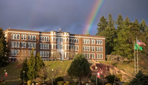 Old Main, the primary campus building, sits atop the hill at the end of a rainbow