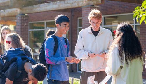 Students sign up for an event at a table outside
