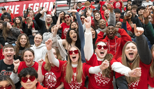 Students cheering in stands, wearing red tshirts