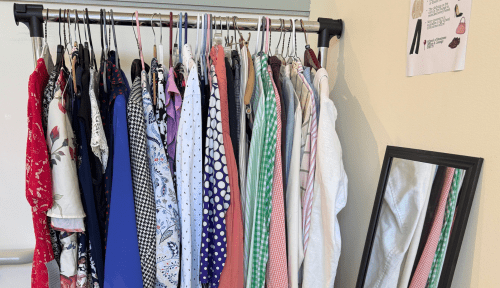 Clothes on a rack and a standing mirror
