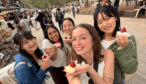 Students hold strawberry desserts outside