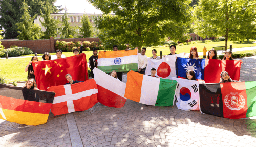 A group of students holding international flags outside