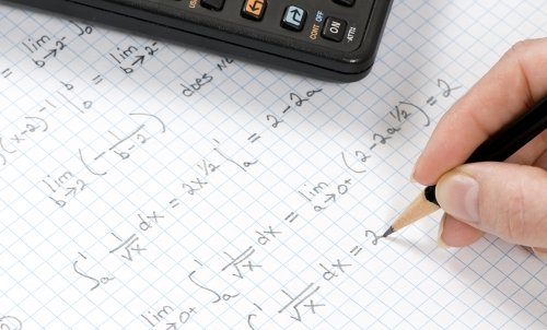 A student works on a math problem with pencil on graph paper.