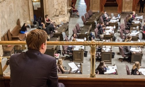 A student watches from the balcony during a legislative session.