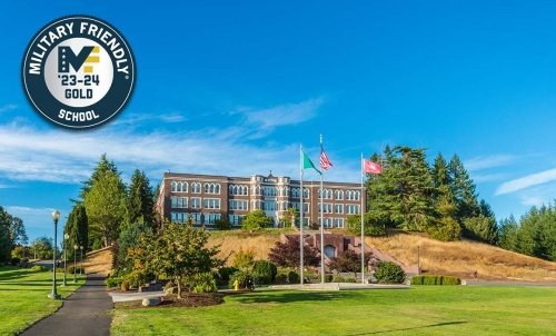 Old Main at the top of the hill on a sunny day, with the Military Friendly School 23-24 Gold badge in the top left corner