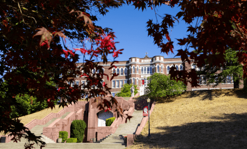 Old Main at the top of the hill, framed by red leaves