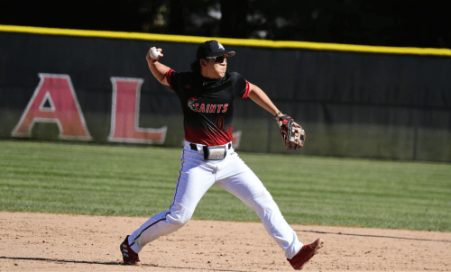 A Saint baseball player in uniform winds up to pitch