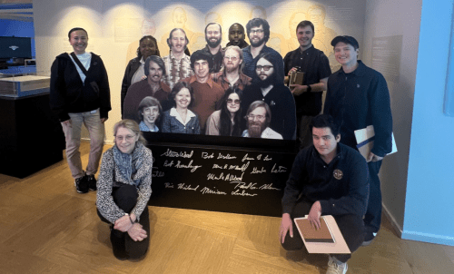 Students and faculty pose with cutout of Microsoft founders