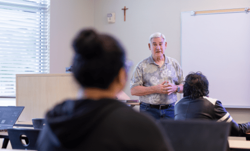 Professor teaches to students at front of classroom