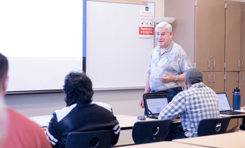 Professor teaches to students at front of classroom