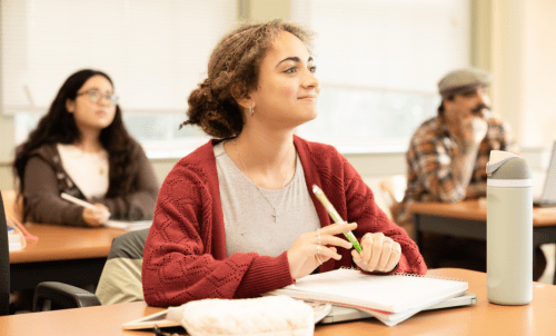 Students listen attentively at desks in a classroom