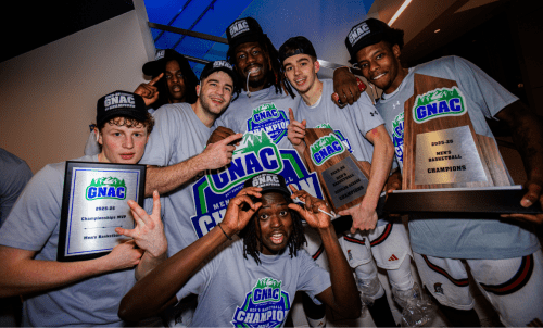 The basketball team wears GNAC tshirts and hold their championship plaques