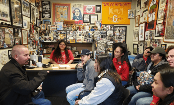 Students listen to a man in a Homeboy Industries office