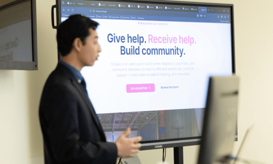 A student presents in front of a screen