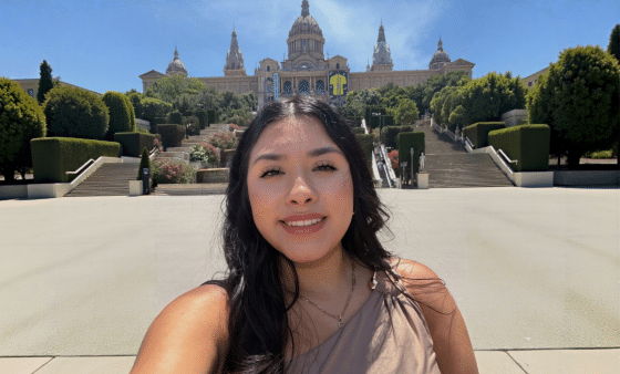 Student selfie in front of ornate building with grad staircase