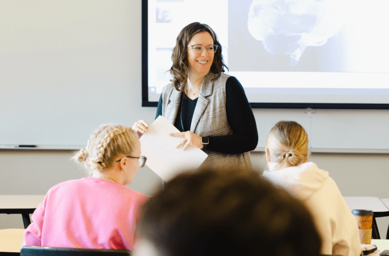 A teacher stands at the front of the class