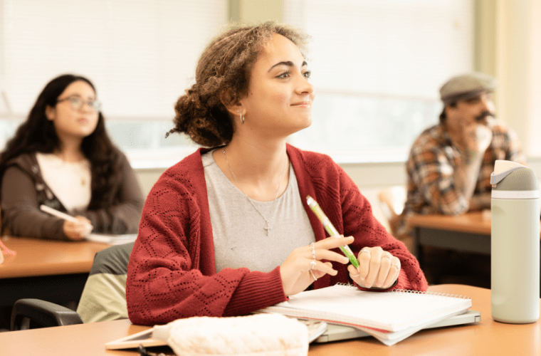 Students listen attentively at desks in a classroom