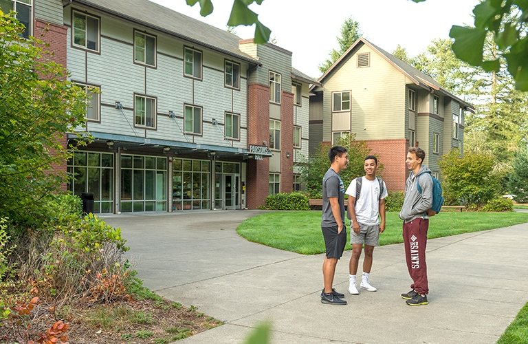 A group of students chatting in front of a dorm