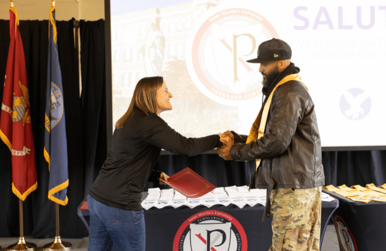A veteran shakes hands with staff as he gets an award