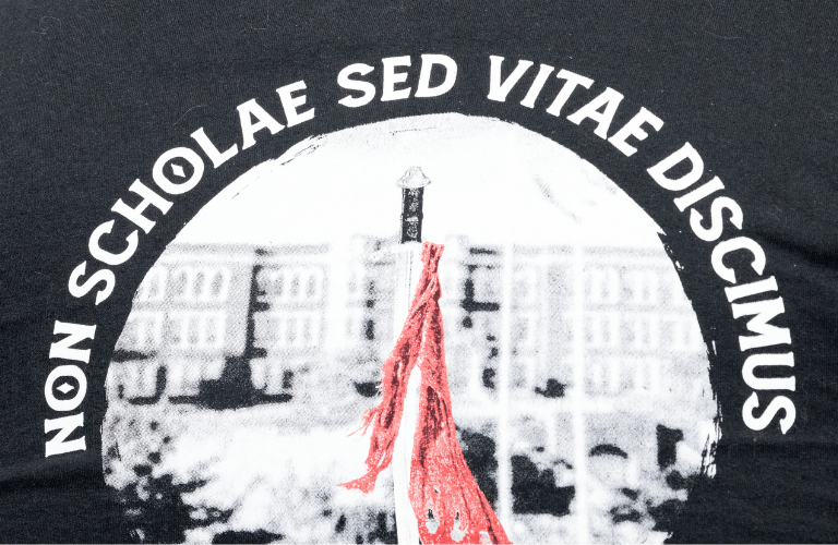 Picture of flag in front of building, with text: non scholae sed vitae discimus