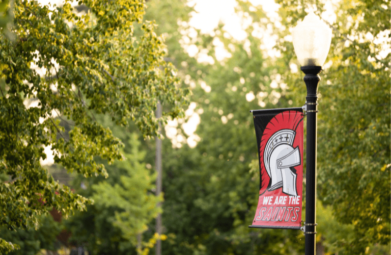 Banner with Roman helmet saying &quot;We are the Saints&quot; in an outdoors space