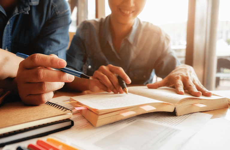 A student studies with a tutor helping