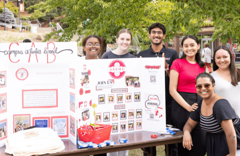Students surround a board advertising their club