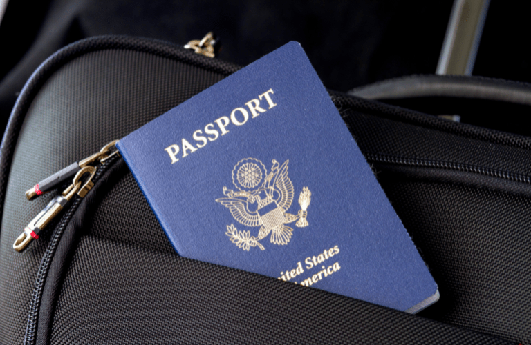 Blue passport tucked into a black suitcase