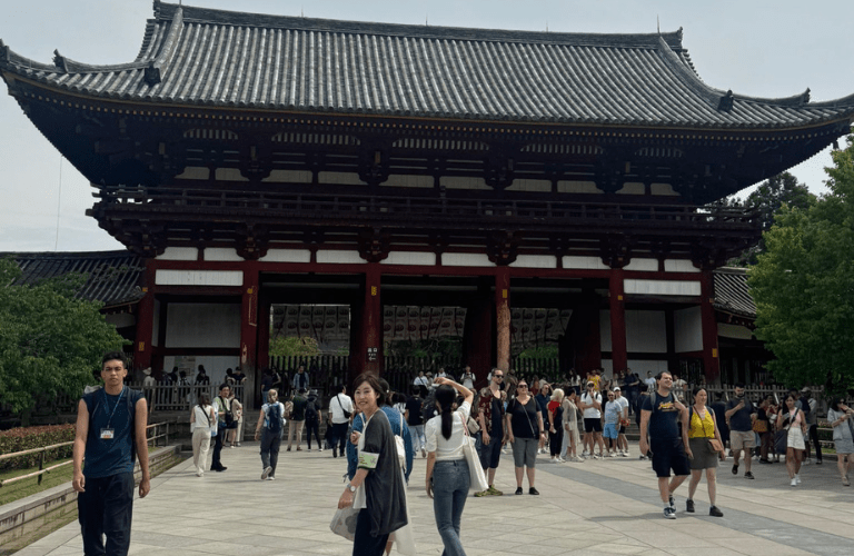 People in front of building with tradition Japanese-style roof