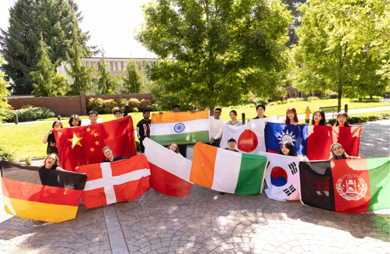 Students hold international flags in a line