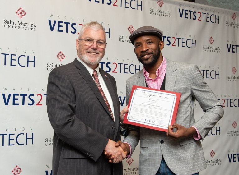 Program graduate holding a certificate with the academic dean.