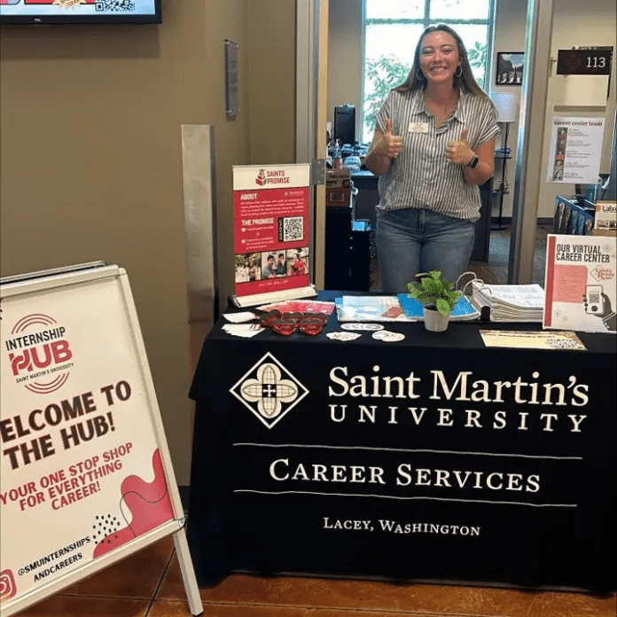 Staff stand behind Career Services table with information on it