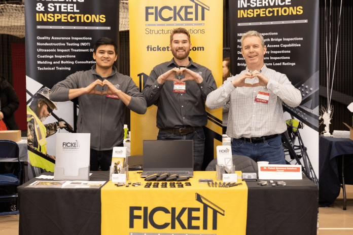 Alumni recruiters makes Saints hearts with hands at employer booth