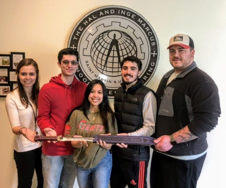 Students hold a sword made at MakerSpace