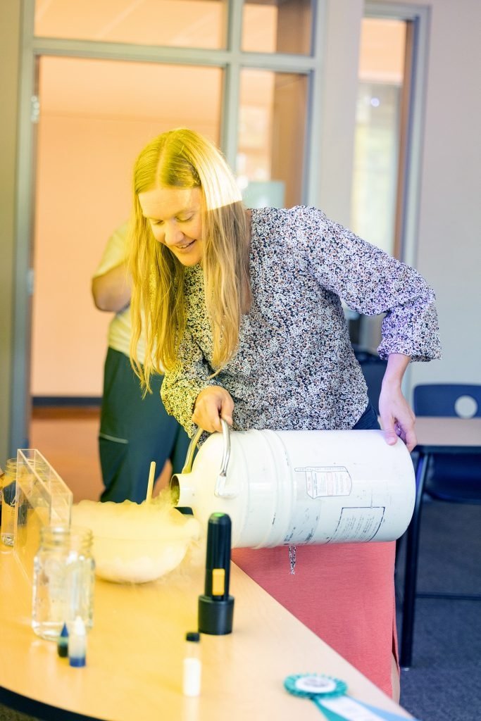 Andrea Kunder pours something misty from a canister into a bowl during a demonstration